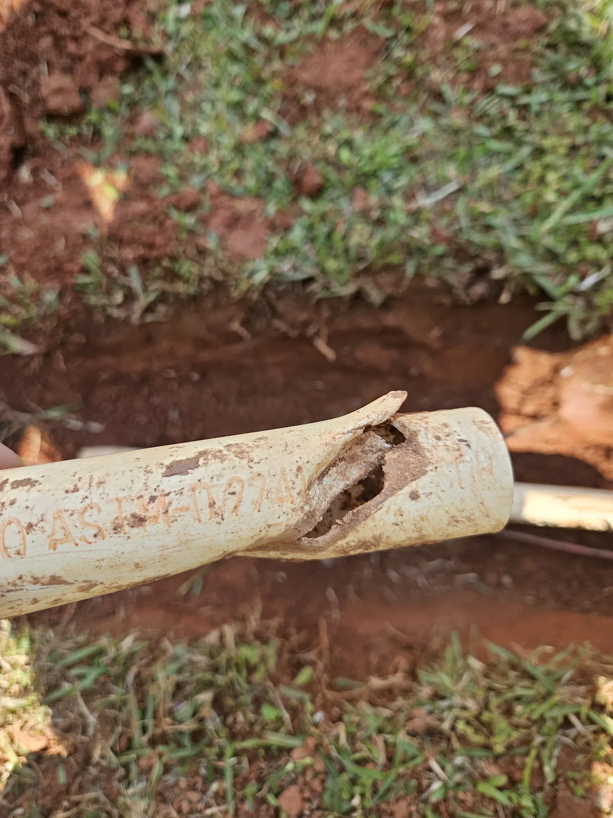 Cracked irrigation pipe close-up before repair in Covington GA