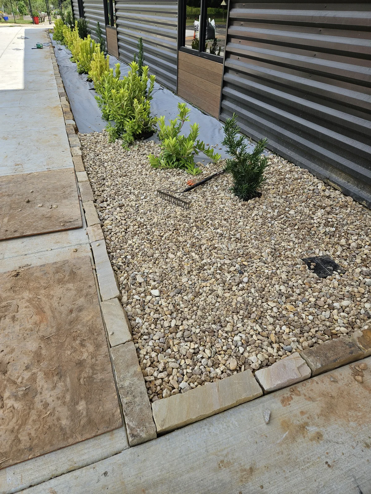 After: Finished commercial planting bed with stone edging and gravel mulch in Covington, GA